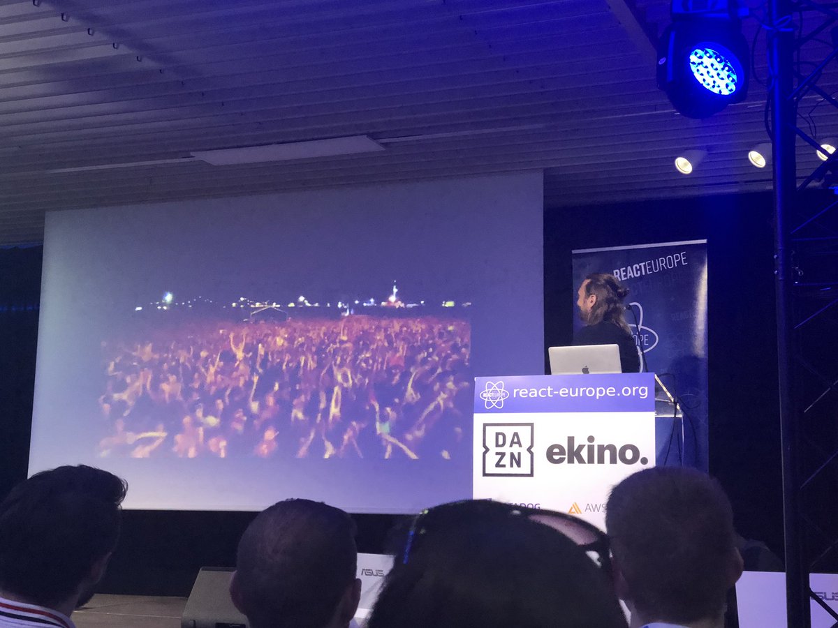 DJ fresh staring at the screen showing a massive crowd cheering to electronic music