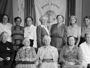 Svartvitt foto av 14 kvinnor som står uppradade.