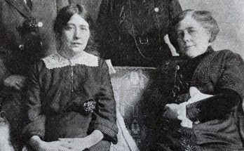 Svartvitt foto av två kvinnor som sitter bredvid varandra i en soffa.