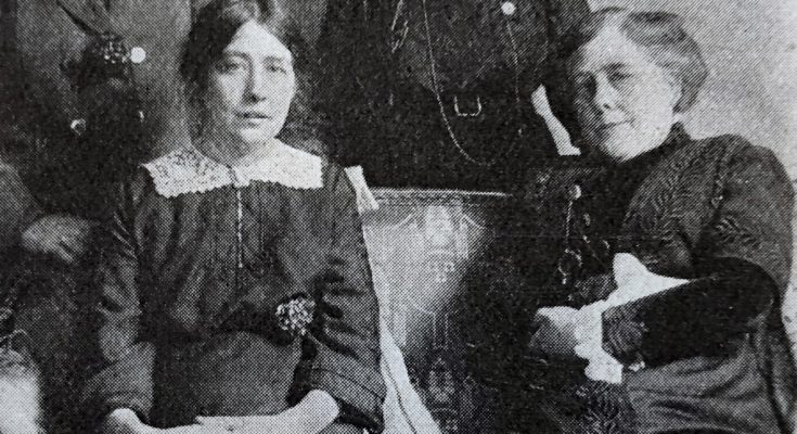 Svartvitt foto av två kvinnor som sitter bredvid varandra i en soffa.