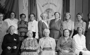 Svartvitt foto av 14 kvinnor som står uppradade.