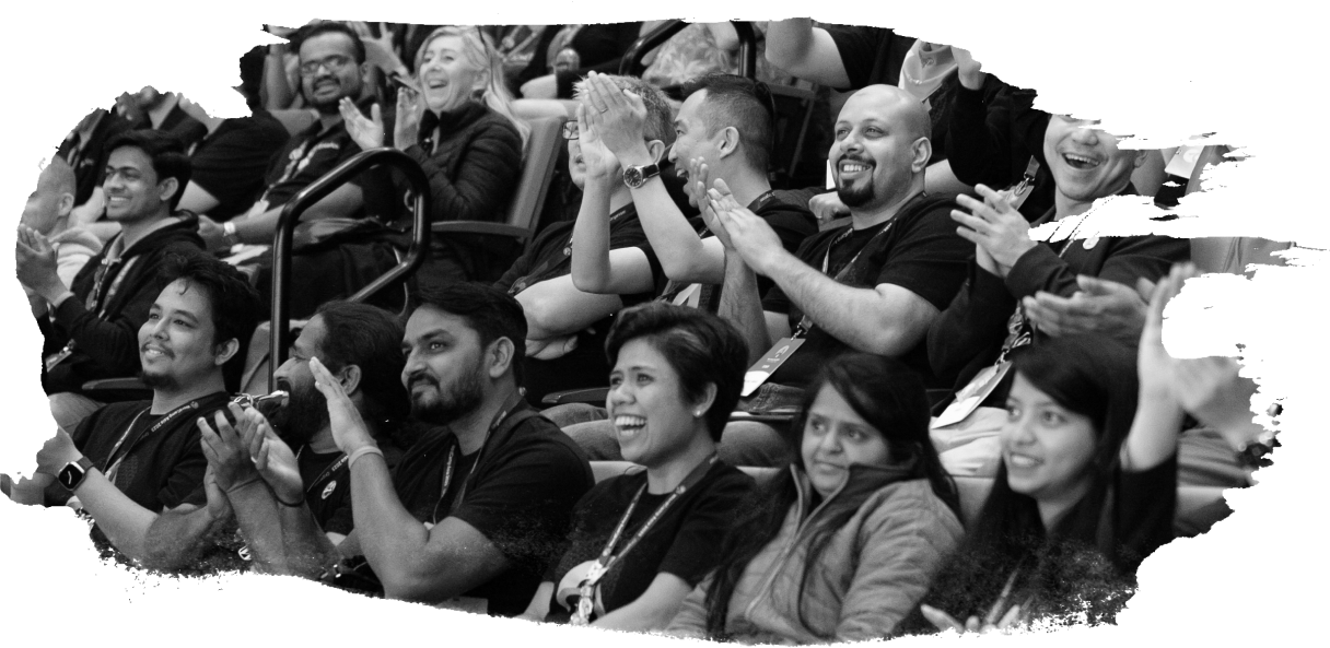 Una fotografía en blanco y negro de asistentes aplaudiendo animados en la audiencia de un evento WordPress.